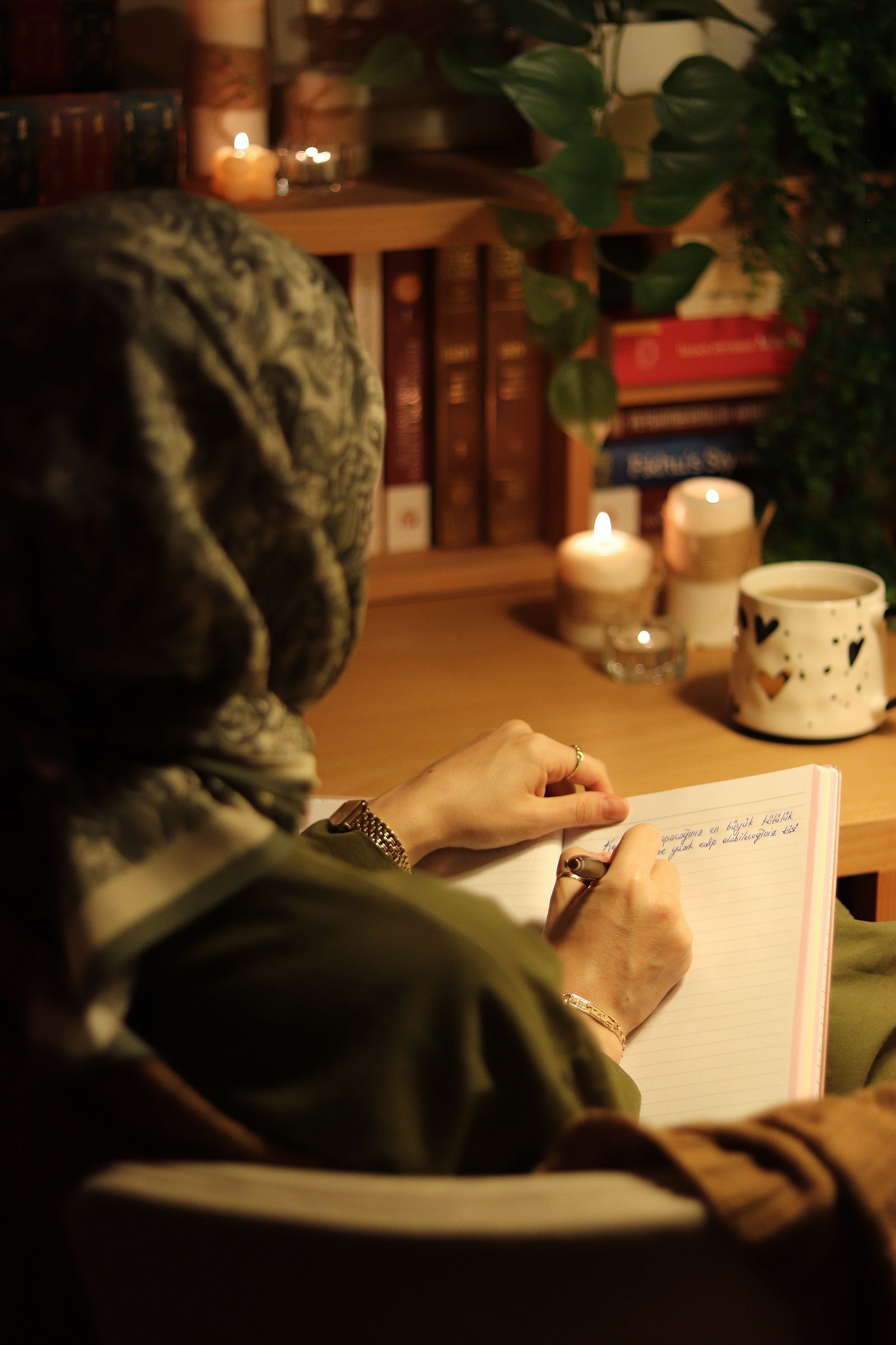 Hand writing a heartfelt letter to God in a journal beside an open Bible