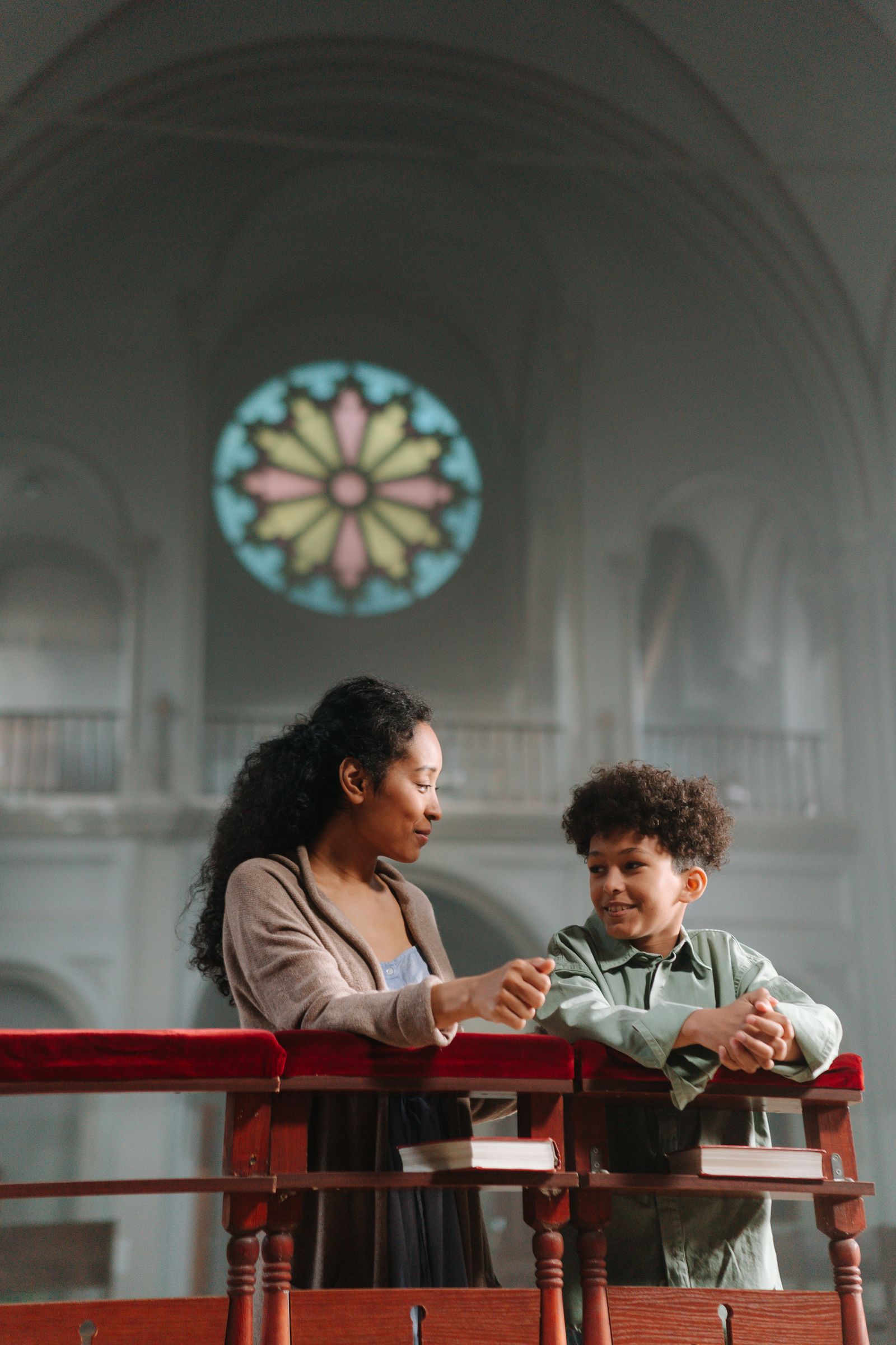 A mother and her child praying together inside a Christian church