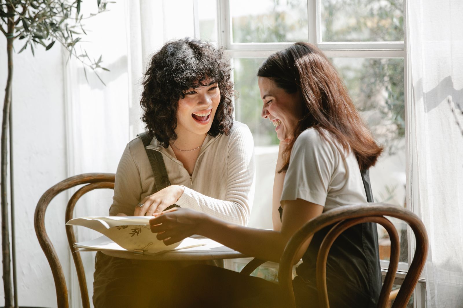 Women laughing together in a sunlit room