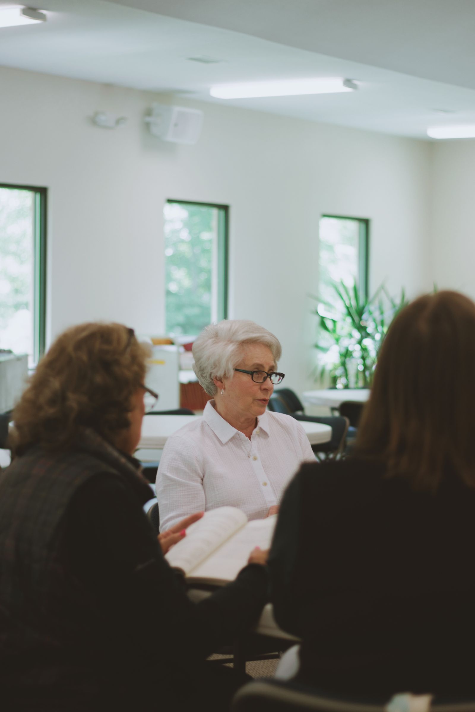 Women gathered around a table for Bible study with open books and notes